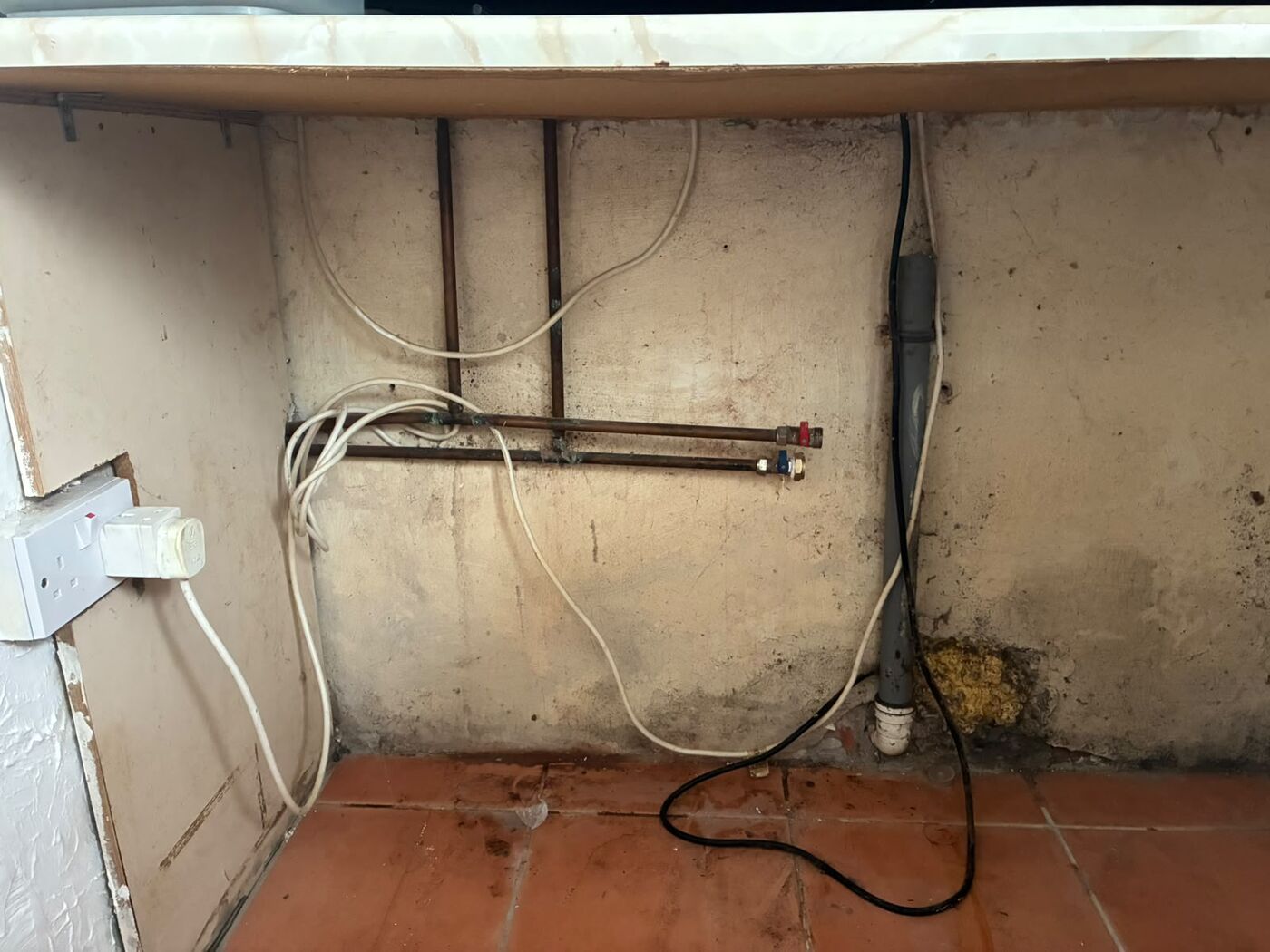 Copper supply pipe work and valves on a utility wall