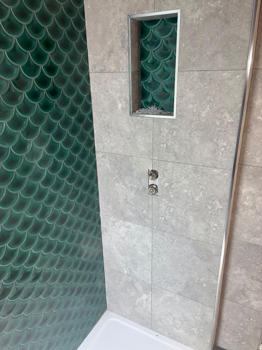 Thermostatic shower valve and tiled niche on grey tiles